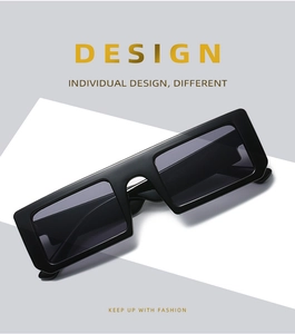Close-up of black rectangular sunglasses with thick frame on geometric background