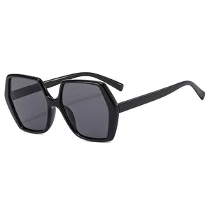 Lunettes de soleil hexagonales noires avec verres gris foncé sur fond blanc uni