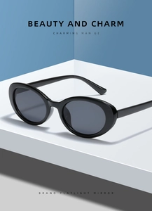 Detail view of vintage oval sunglasses on a geometric stand with polished black frames