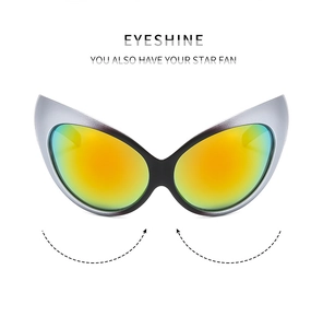 Close-up of futuristic Y2K wraparound sunglasses with silver frame and orange lens