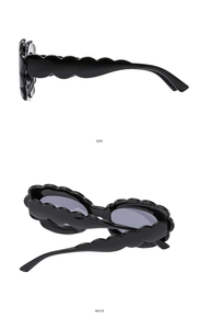 Vue détaillée des lunettes de soleil noires avec monture festonnée et profil latéral chic