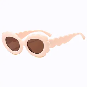 Lunettes de soleil tendance à monture ondulée rose clair avec des verres marron chic