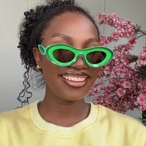 Y2K oval cat-eye sunglasses with bright green translucent frames and dark lenses