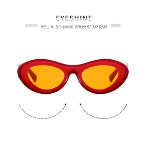 Close-up of Y2K oval sunglasses featuring bold red frames and orange tinted lenses
