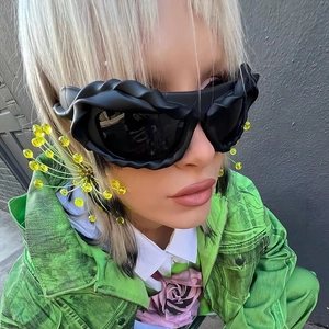 Detail of Y2K avant-garde oversized sunglasses with unique black woven texture frames