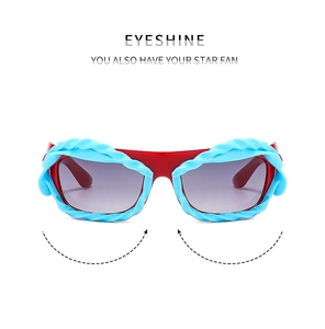 Detail of red irregular Y2K sunglasses with blue spiral decor and gradient purple lenses