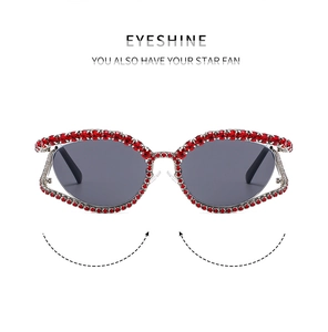 Detail of luxury cat-eye sunglasses with red rhinestones and dark grey lenses