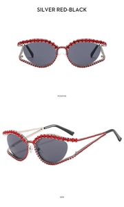 Detail of silver cat eye sunglasses with luxury red rhinestone crystals and dark lenses