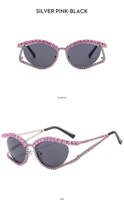 Close-up of luxury silver cat-eye sunglasses with pink rhinestone frame embellishments