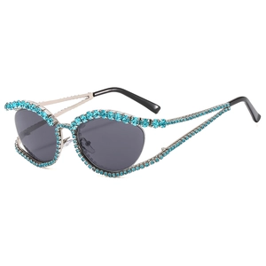 Luxury cat eye sunglasses with light blue rhinestones and gray lenses on a white background