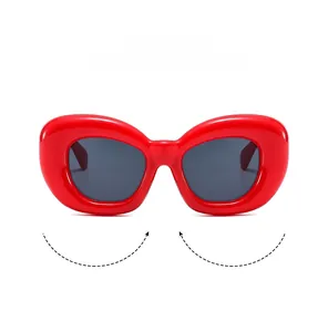Détail de lunettes de soleil rouges gonflées avec verres ovales gris pour un look Y2K