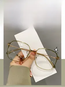 Detail of TR90 glasses frame showing tea-colored transparent rims and golden metal temples