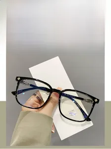Detail of TR90 glasses frame showing metal cross emblem and blue light filter sticker