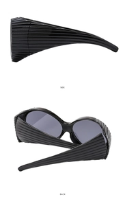 Détail de lunettes Y2K avec texture côtelée horizontale sur les branches larges noires