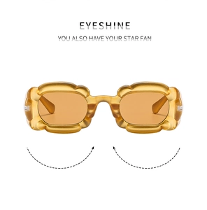 Détail de lunettes de soleil ambrées avec monture épaisse ondulée au design moderne