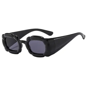 Lunettes de soleil noires à monture florale avec fini brillant et bords ondulés
