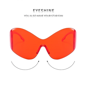 Detail view of red Y2K futuristic wrap-around sunglasses with a trendy oversized frame