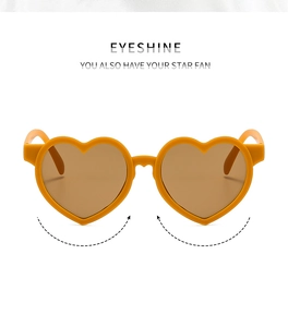 Détail de lunettes de soleil cœur orange vif avec verres bruns et charnière métal