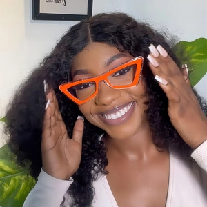 Chic orange cat-eye blue light glasses with glitter finish worn by a smiling model