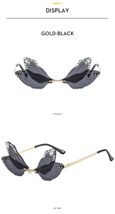Frameless butterfly wing sunglasses with gold-black frame, rhinestones and bee details