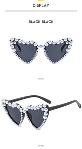 Detail of heart sunglasses with double row faux pearl trim and dark black lenses