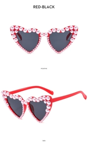 Detail of red heart-shaped sunglasses with pink pearls and dark lenses from two angles
