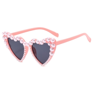 Pink heart-shaped sunglasses with pearl trim and dark lenses shown from a side view