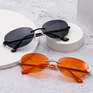 Retro Y2K rimless oval sunglasses with orange and black lenses on a display stand