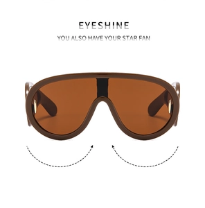 Detail of dark brown shield sunglasses with orange lenses and golden metal hinges