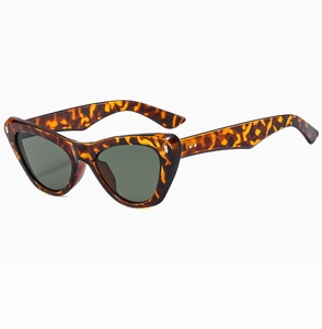 Detail of cat-eye sunglasses featuring leopard print frame and dark green lenses