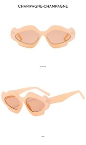 Detailed front and side view of champagne wavy irregular frame sunglasses with orange lenses