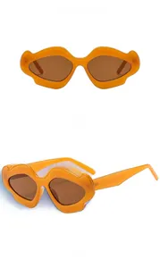 Detail view of wavy orange frames and brown lenses on stylish chunky sunglasses