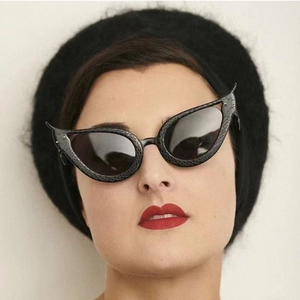 Lunettes de soleil œil-de-chat chic avec monture serpent noire sur un mannequin