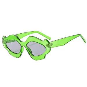Lip-shaped sunglasses with translucent green frame and grey lenses on white background