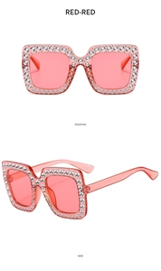 Detail einer roten eckigen Kinder-Sonnenbrille mit funkelnden Strasssteinen am Rahmen