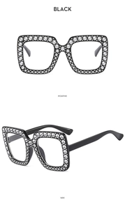 Nahaufnahme der schwarzen quadratischen Kinder-Sonnenbrille mit glitzernden Strasssteinen und Retrostil