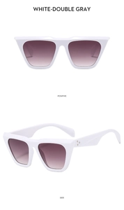 Detail of white oversized sunglasses with double gray lenses and side rivet accents