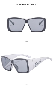 Detail view of silver Y2K sports sunglasses with light gray lenses and rivet accents