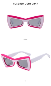 Close-up of butterfly sunglasses in rose red and white with grey tinted lenses