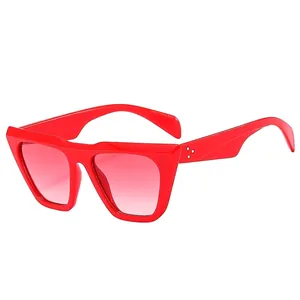 Fashionable oversized red cat-eye sunglasses with gradient pink lenses and metal rivets
