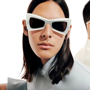 Fashionable white butterfly sunglasses with black lenses shown on model in a studio setting