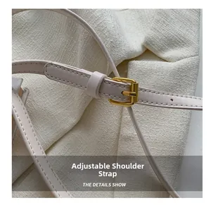 Detail view of adjustable shoulder strap with gold buckle and fine stitching on square bag