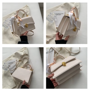 Detail of off-white square handbag featuring gold twist lock and printed silk scarf handle
