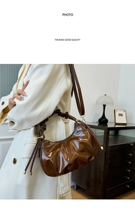 Detail of caramel brown oil wax leather cloud bag with elegant pleated texture and gold zipper