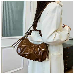 Detail of dark brown glossy pleated cloud bag with scrunchie handle and shoulder strap