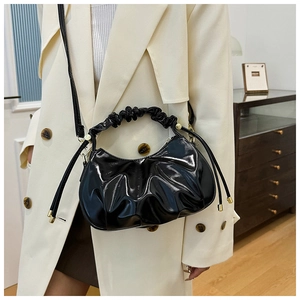 Black pleated oil wax leather cloud bag shown on model with crossbody strap