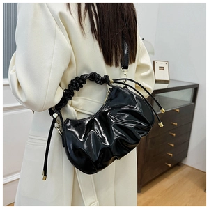 Close-up of black pleated oil-wax leather cloud bag with gold hardware and zipper