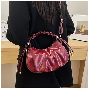 Detail of burgundy ruched cloud bag in oil wax leather with adjustable shoulder strap