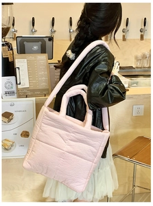 Detailed view of the pink quilted tote bag showing texture and coffee shop scene styling.