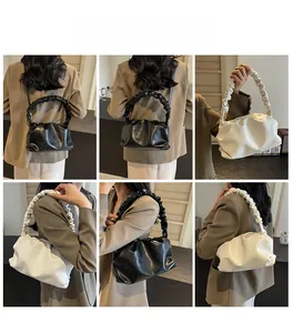 Close-up of pleated cloud dumpling bag in black and beige with scrunchie straps